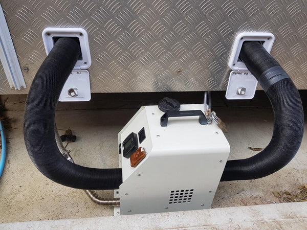 Portable diesel heater connected to a campervan with warm air and return air ducts and a security cable lock