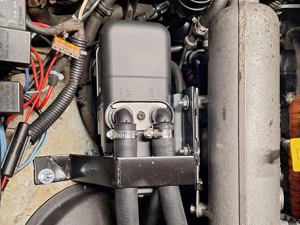 Vvkb Apollo GC5 gasoline water heater installed in vehicle engine bay showing coolant IN/OUT connections and mounting bracket